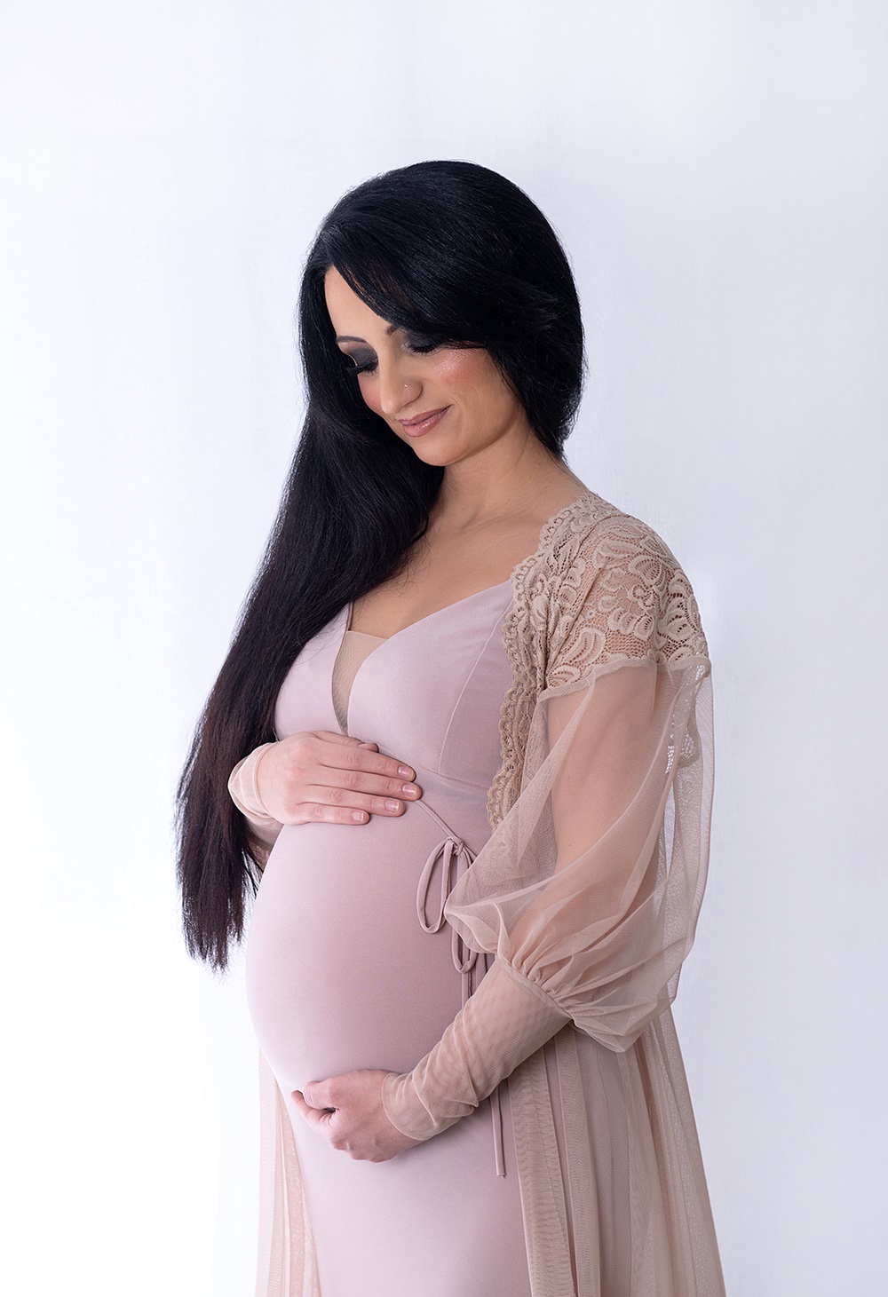 Schwangere Frau umarmt ihren Babybauch